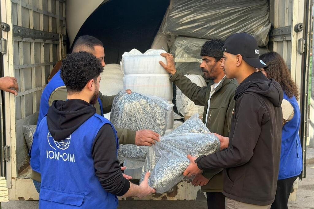 Les déplacements au Liban Des travailleurs de l'OIM en gilets bleus déchargent des fournitures d'aide d'un camion pour aider les personnes déplacées au Liban.