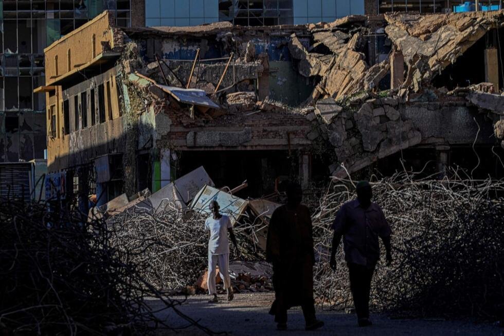 Des Soudanais passent devant un bâtiment détruit dans la capitale, Khartoum, le 16 avril 2026, alors que la guerre qui ravage le pays, opposant les militaires aux paramilitaires, est entrée dans sa qu