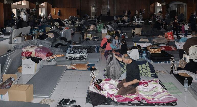 Des familles déplacées vivant dans un abri d'orphelinat au Liban, entourées de matelas et d'effets personnels après avoir fui les attaques israéliennes.