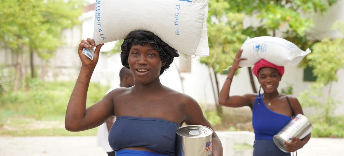 Des femmes en Haïti transportent de la nourriture distribuée par le PAM.