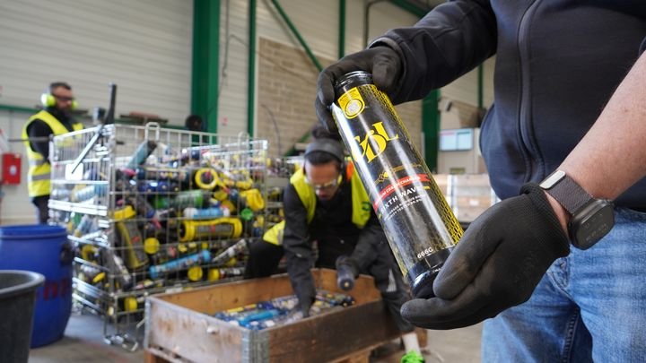 Les employés de l'entreprise D.I. Services (Seine-et-Marne) trient les bonbonnes de protoxyde d'azote avant leur traitement. (MARC BERTRAND / FRANCEINFO)