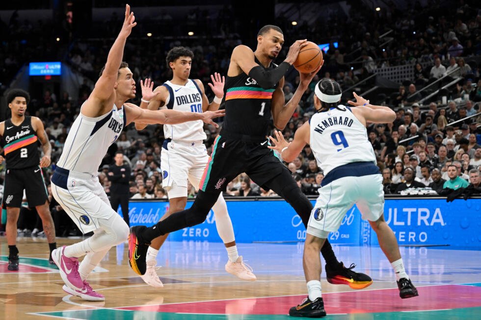 Le pivot des San Antonio Spurs, Victor Wembanyama, s'élance face à Ryan Nembhard des Dallas Mavericks lors de la seconde mi-temps d'un match de basket-ball de la NBA, vendredi 10 avril 2026, à San Ant