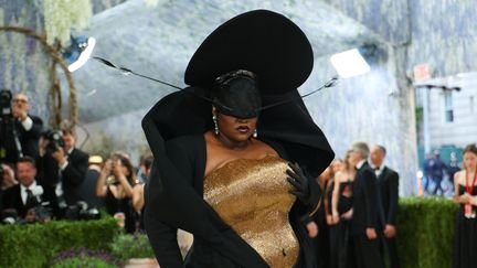 Pour son premier Met Gala, la chanteuse française Yseult est venue parée d'un corset doré et d'une robe noire col bénitier plongeant, signés Harris Reed. D'autres Françaises étaient présentes, comme Léna Mahfouf (également connue comme Léna Situations) - qui portait une robe Burc Akyol, célèbre pour ses bustiers en forme de main à même les seins - ou encore Charlotte Gainsbourg, habillée en Saint Laurent. (ANGELA WEISS / AFP)