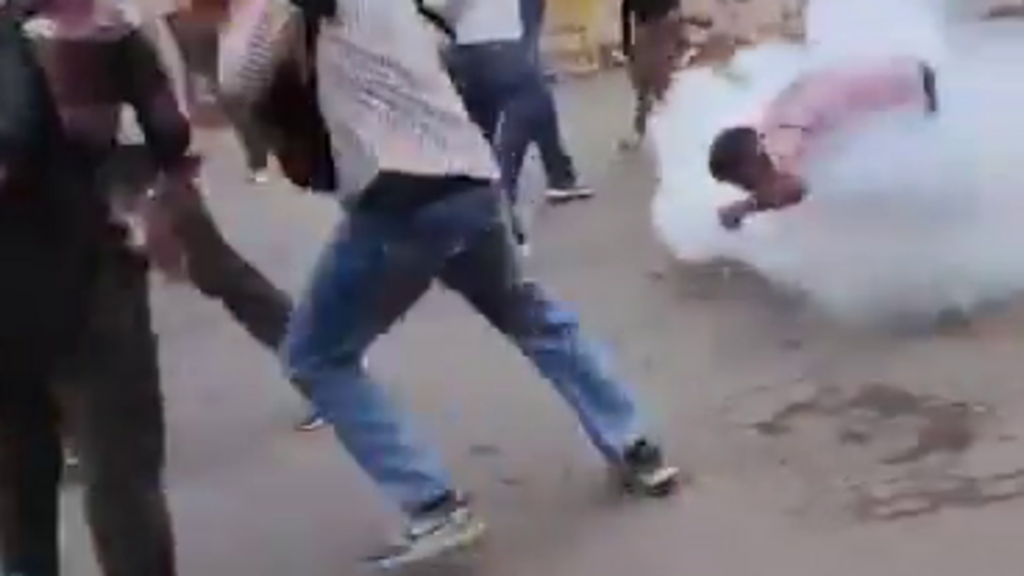 Sur cette vidéo, on peut voir un jeune homme participant au mouvement de Jantar Mantar assis par terre. Une grenade explose à ses pieds, le projetant en l'air avant de diffuser un nuage de fumée. Il semble s'agir d'une grenade de maintien de l'ordre destinée au désencerclement des policiers.