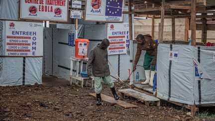 Une personne désinfecte les pieds d'un patient à l'entrée du centre de traitement Ebola (CTE) de Rwampara, à Bunia (Ituri), dans l'est de la République démocratique du Congo, le 13 juillet 2026. (BENEDICTION MURHABAZI / AFP)